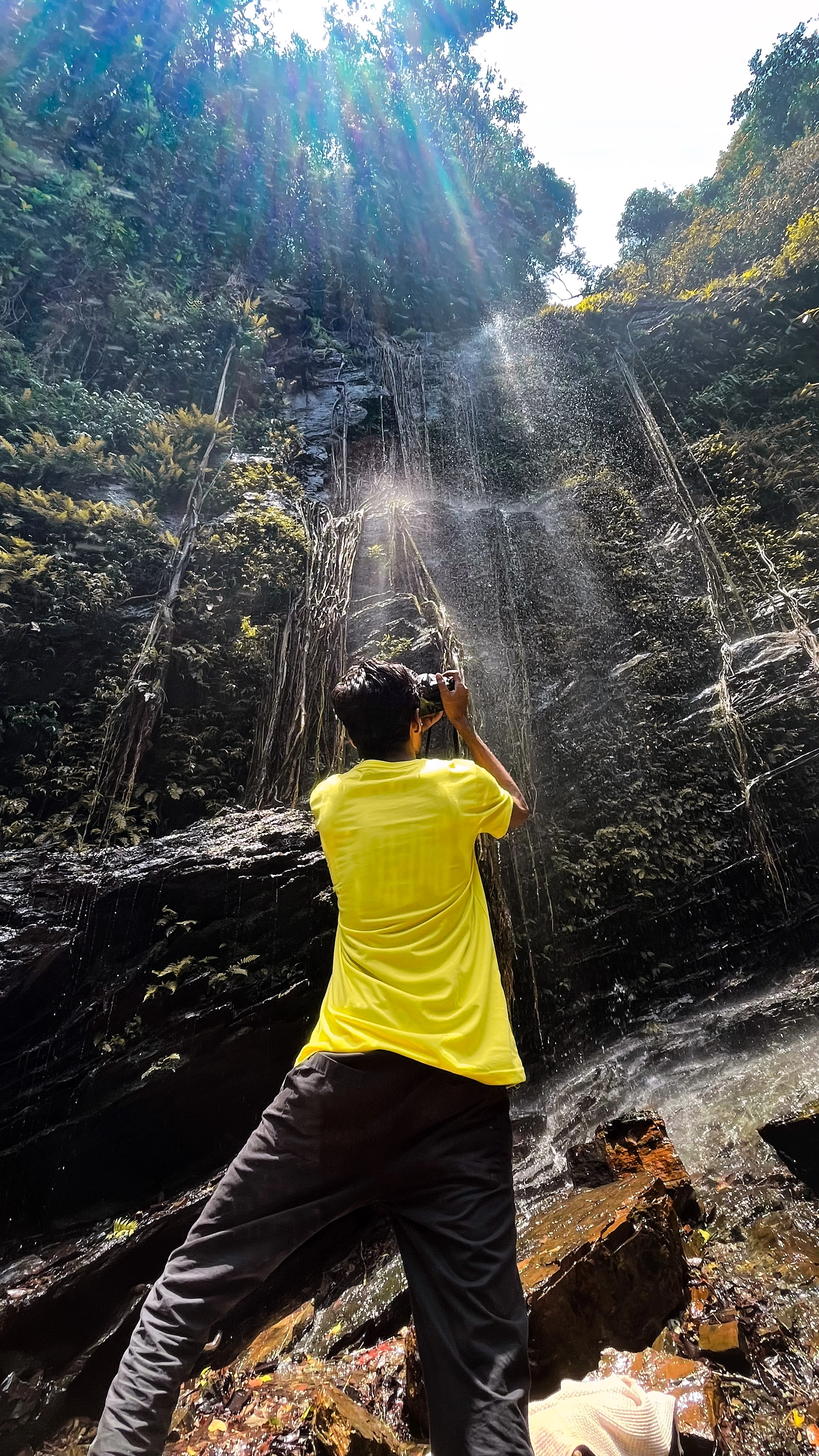 Photographing a waterfall from below, light breaking through the canopy